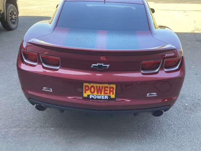 A red chevrolet camaro with a power power license plate