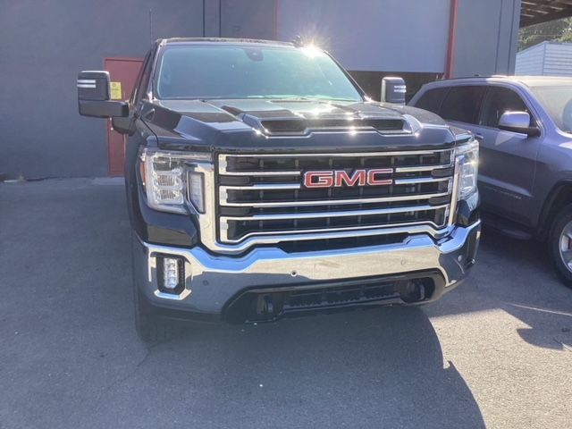 A black gmc truck is parked in front of a building.