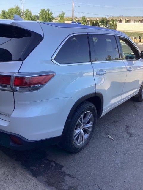 A white suv is parked on the side of the road.
