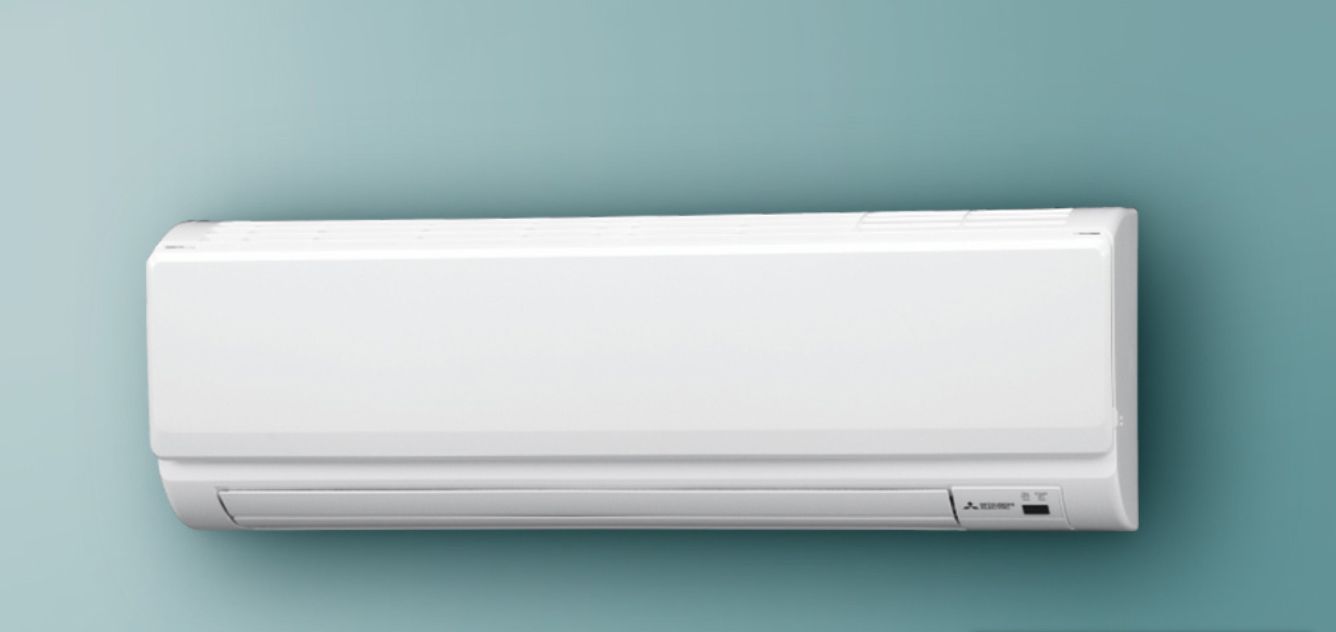 White air conditioner mounted on a teal wall.