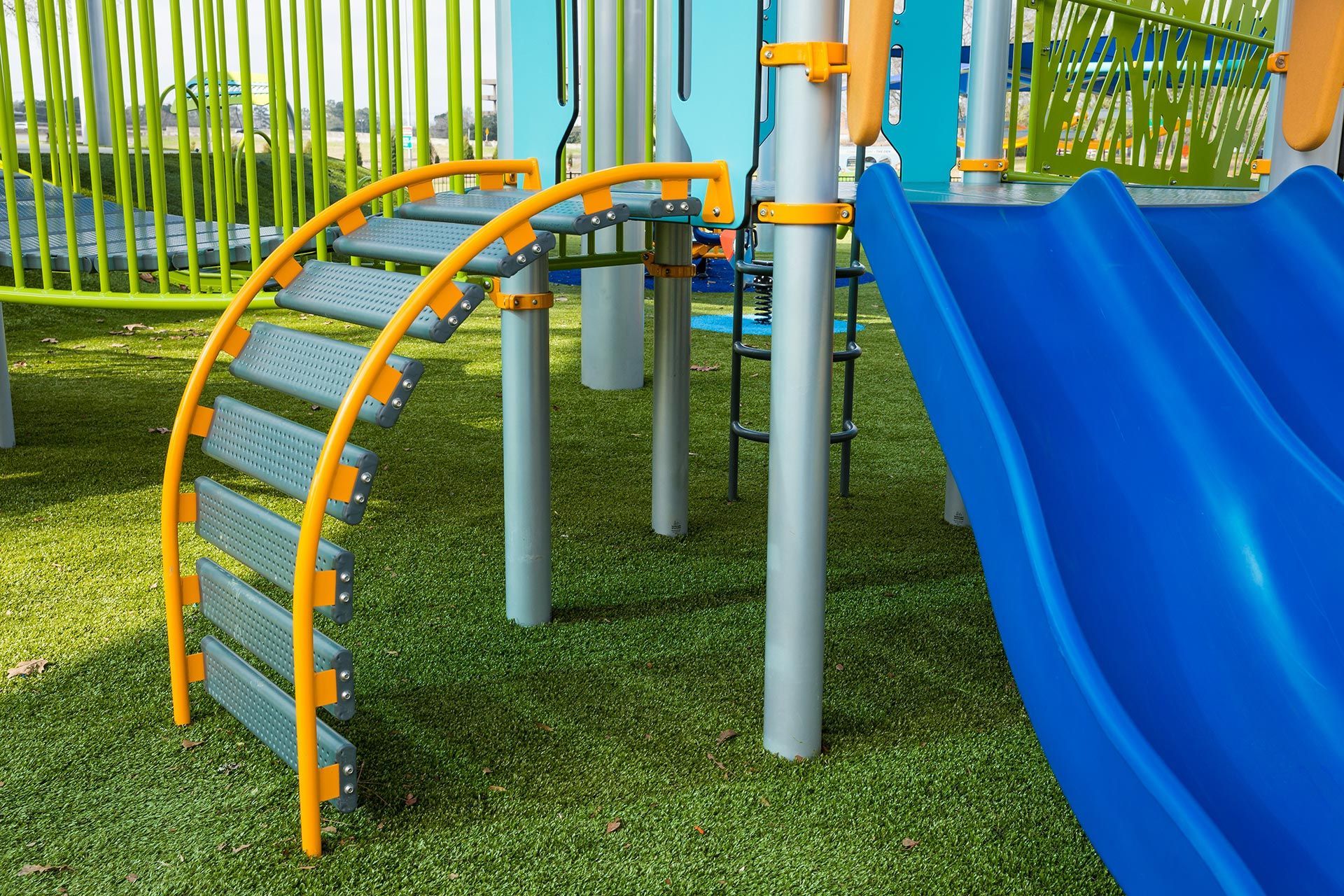 A colorful playground with a blue slide and stairs.