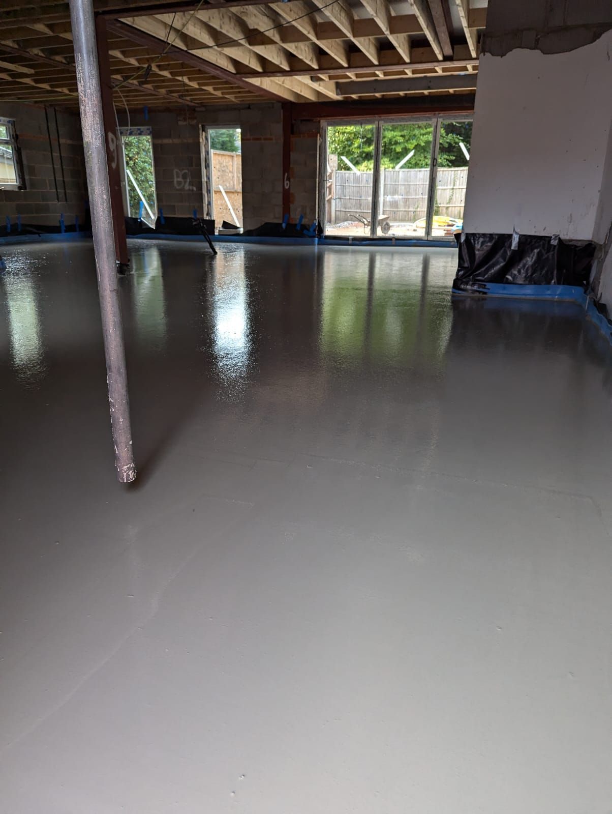 screed installer pouring screed on top of underfloor heating