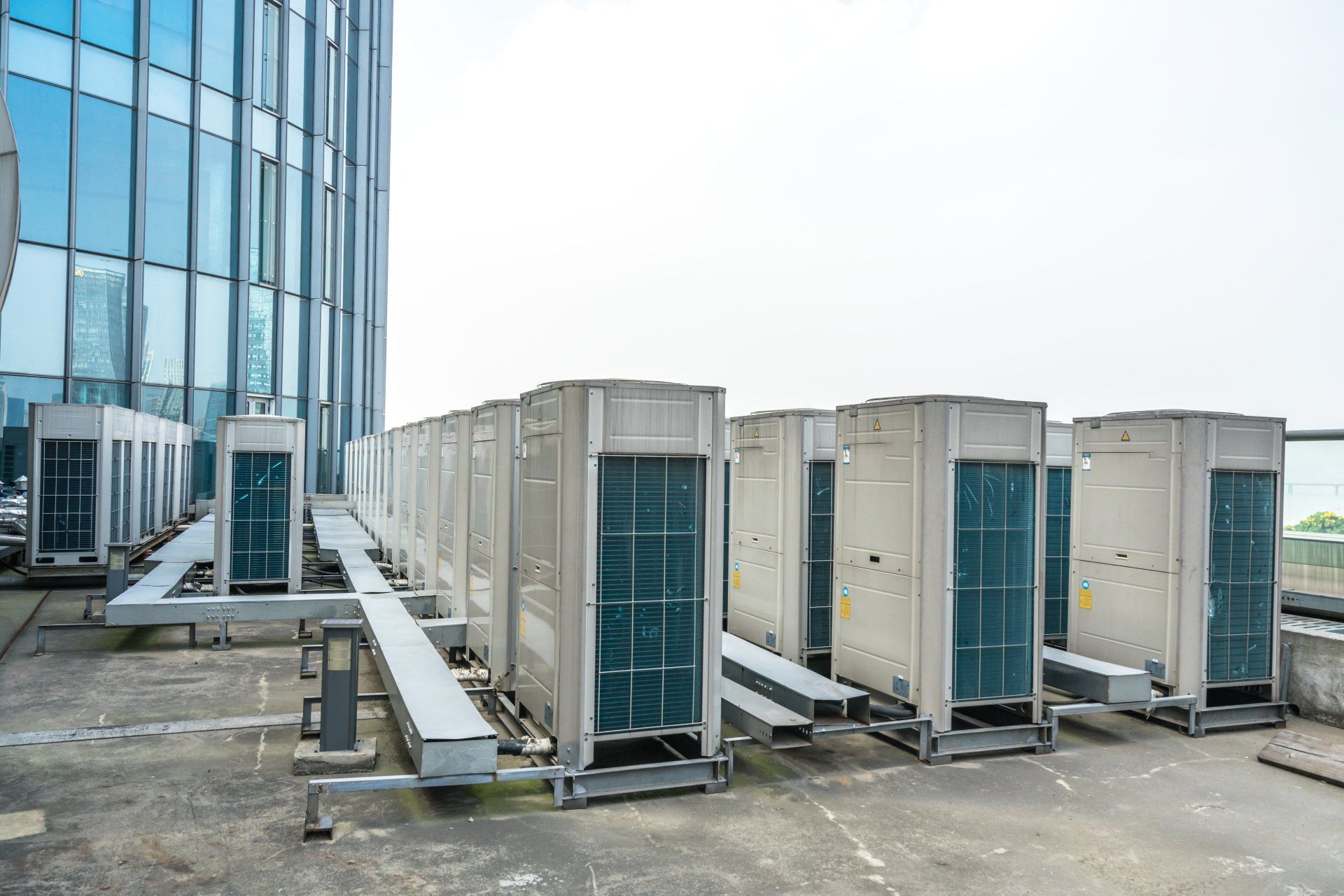 A row of air conditioners on the roof of a building.