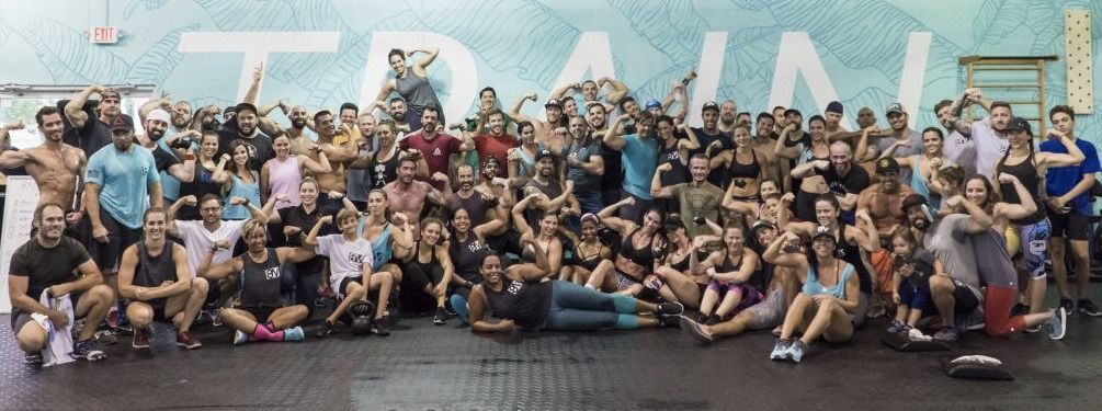 A large group of people are posing for a picture in a gym.