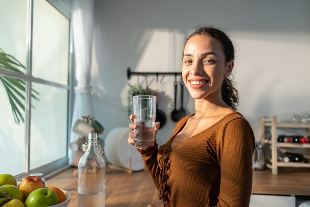 Young beautiful Latino woman holding clean water