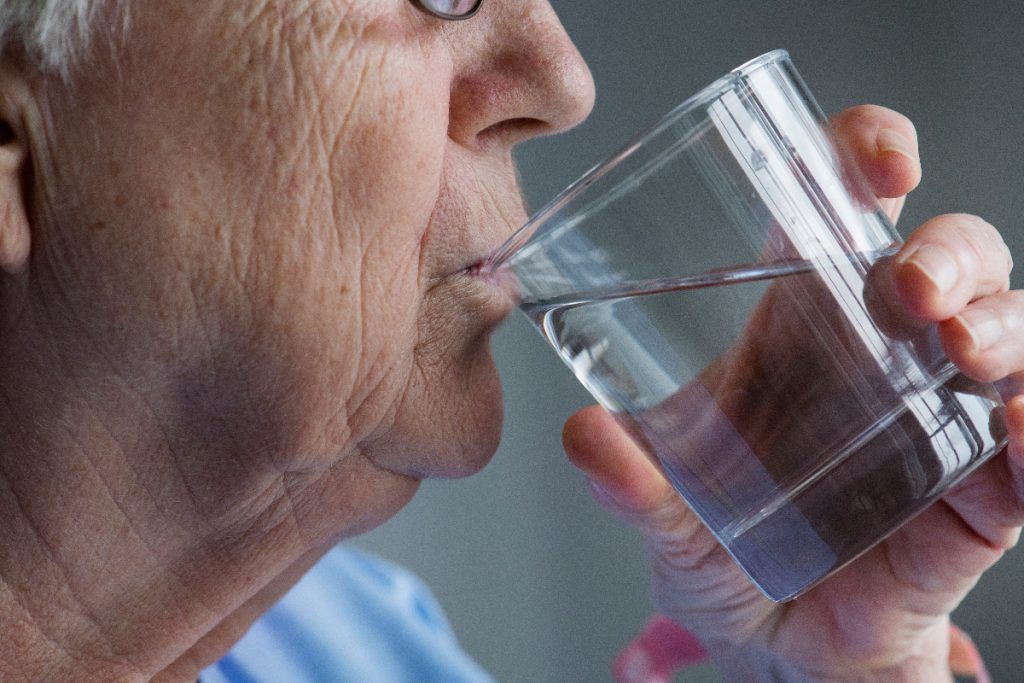 woman is drinking a glass of water