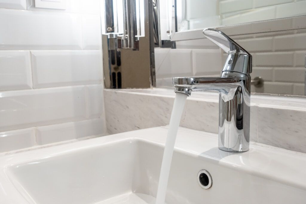 A bathroom sink with water running from the faucet