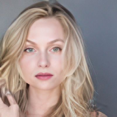 A woman with long blonde hair and green eyes is looking at the camera.