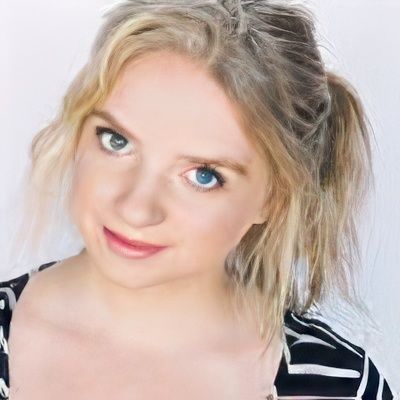 A woman with blonde hair and blue eyes is wearing a black and white striped shirt