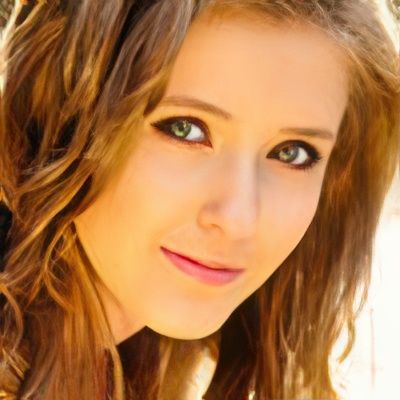 A close up of a woman 's face with brown hair and green eyes