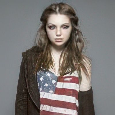 A woman wearing an american flag tank top and a brown jacket