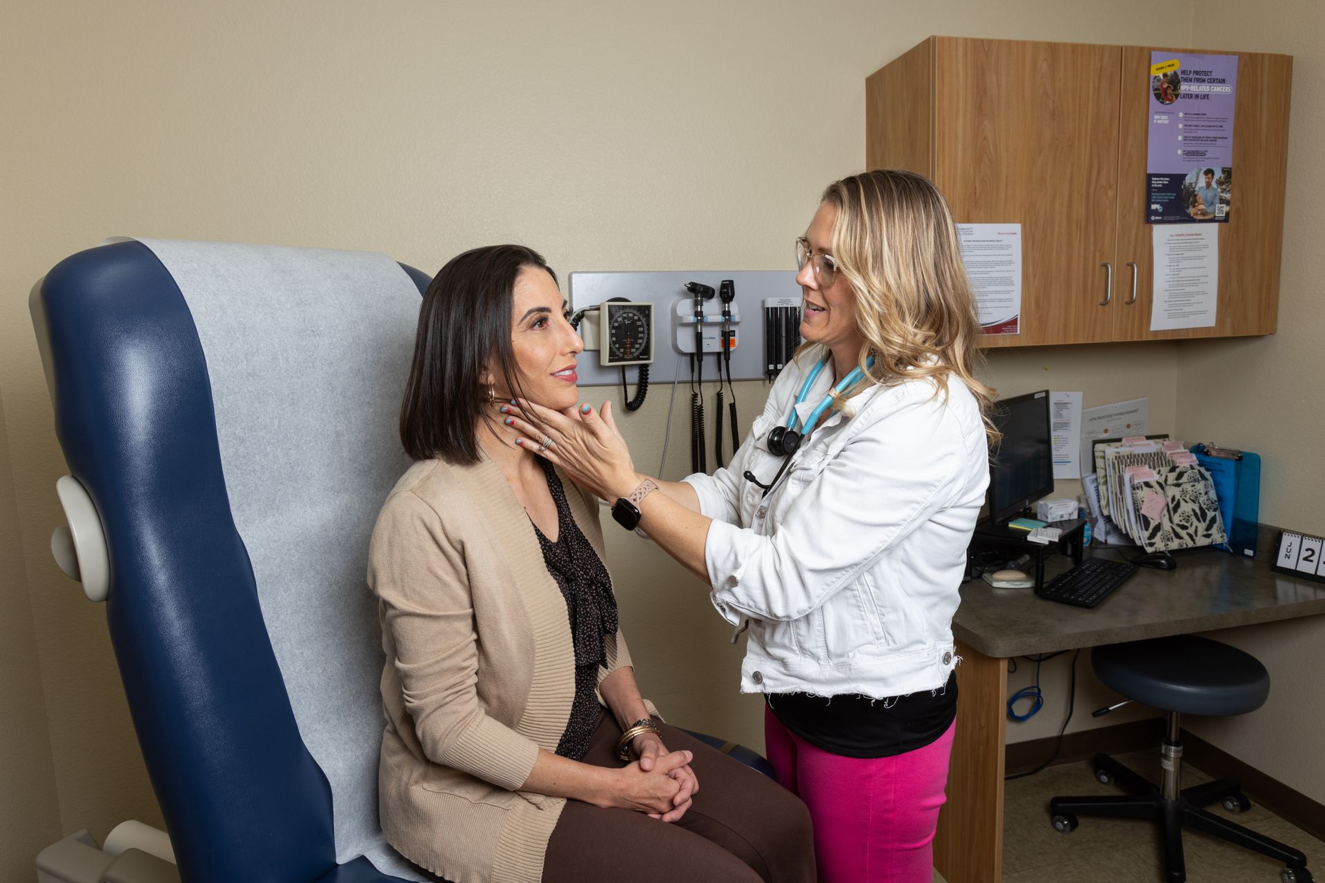 Doctor using a stethoscope to listen to a patient's chest in an office setting.