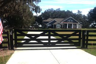 A house with a black gate and an american flag in front of it.