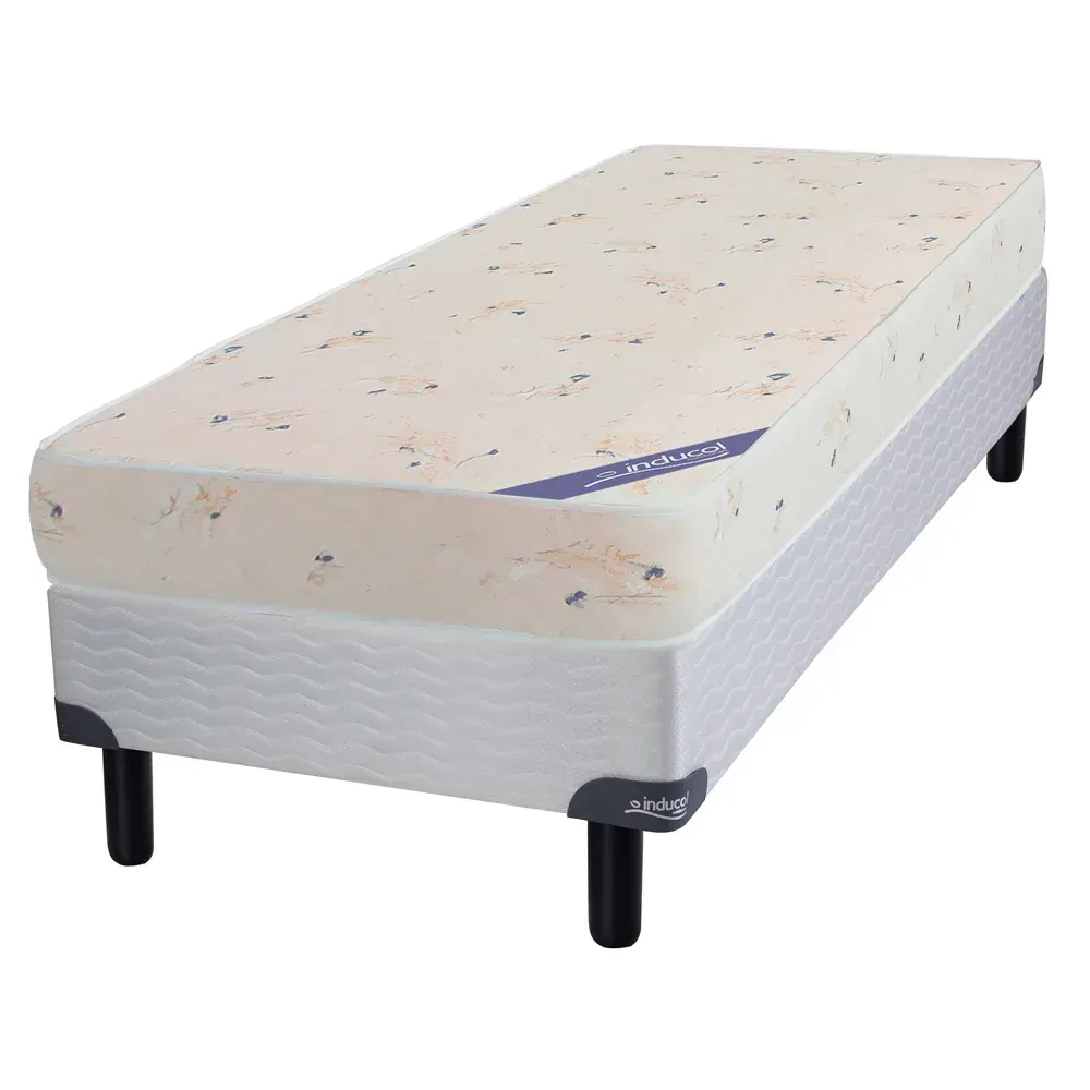 Colchón rectangular color beige con motas, con una etiqueta azul visible.