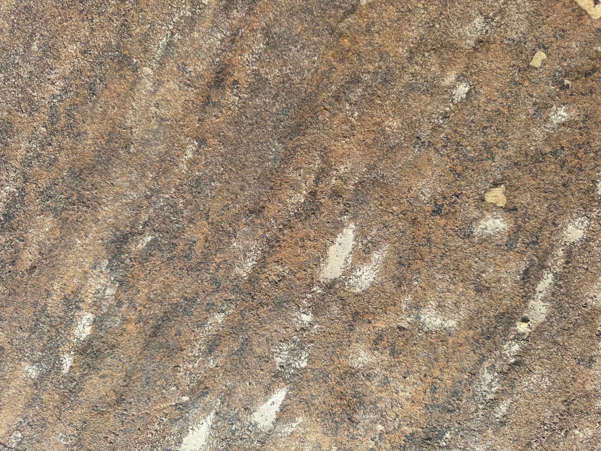 A close up of a brown granite counter top with white spots.