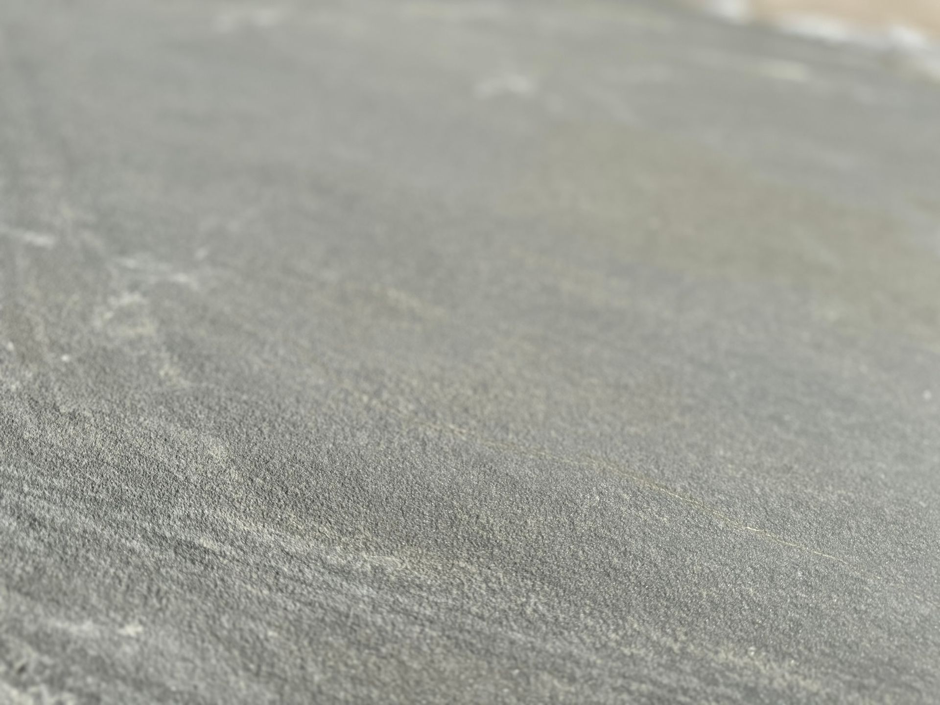 A close up of a gray stone surface with a grainy texture.