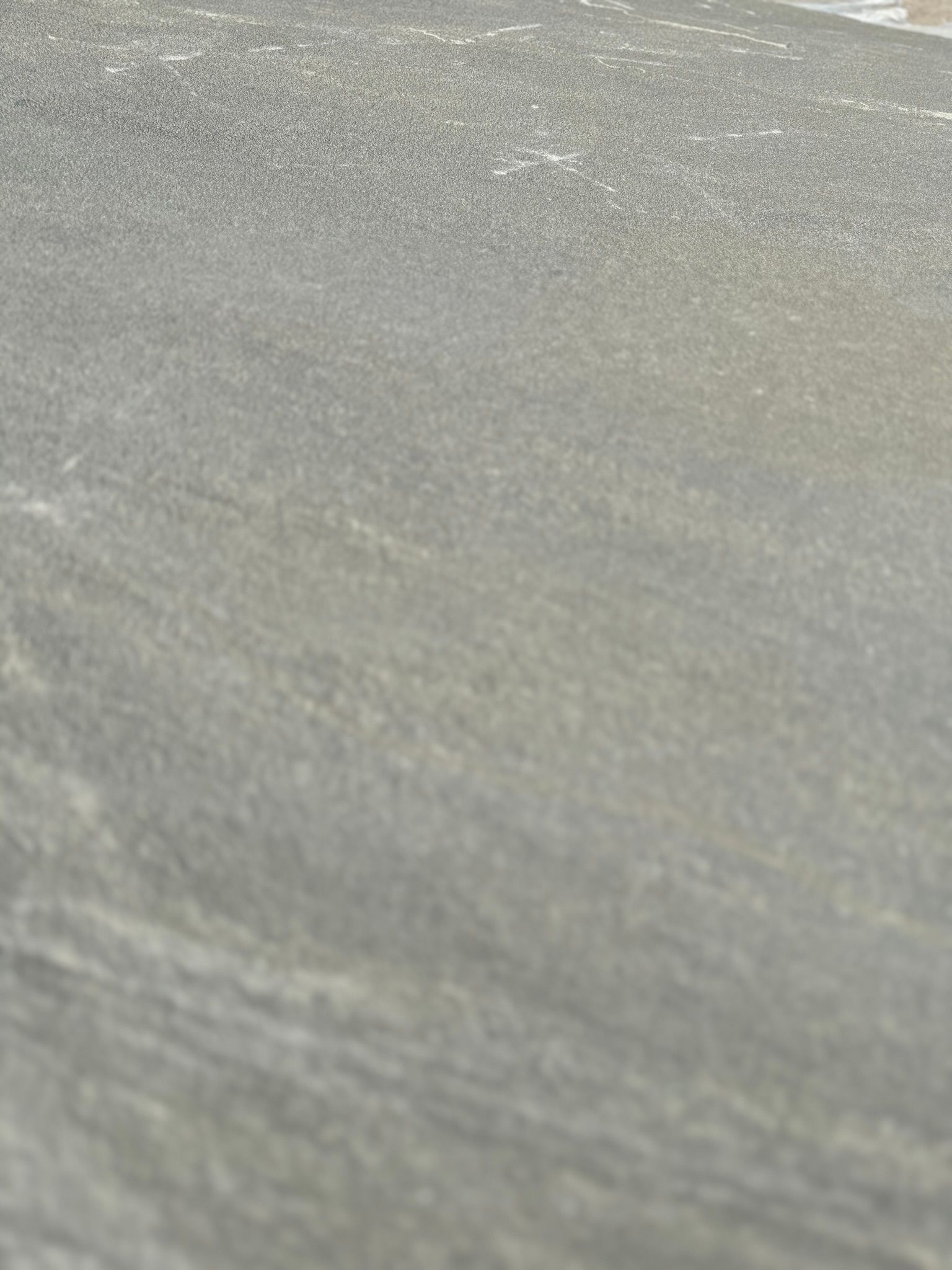 A close up of a gray asphalt road.