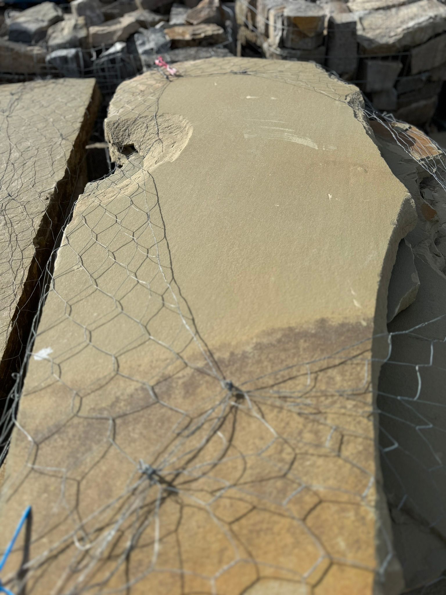 A large piece of stone is sitting on top of a pile of rocks.