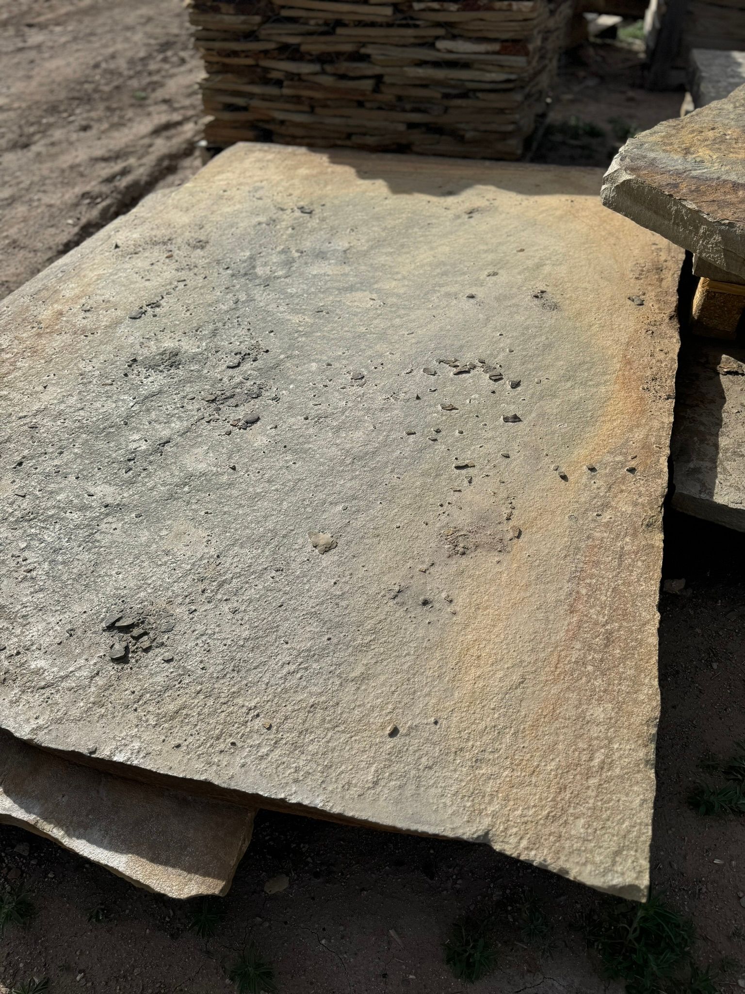 A large piece of wood is sitting on top of a pile of rocks.