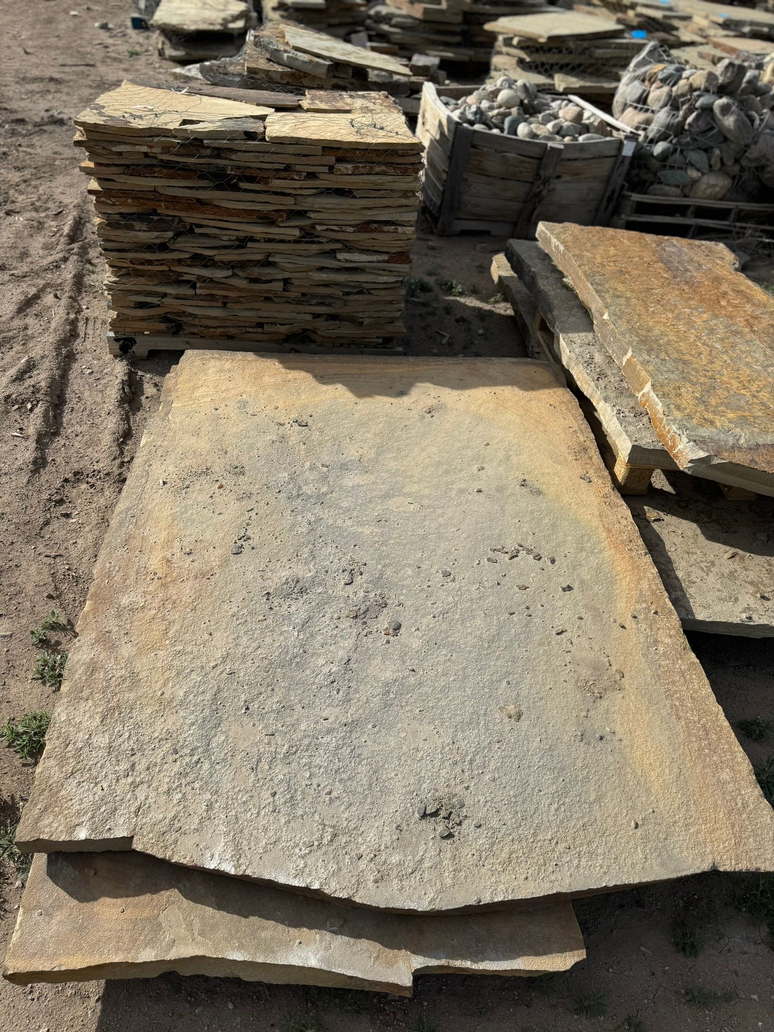A large piece of wood is sitting on top of a pile of rocks.