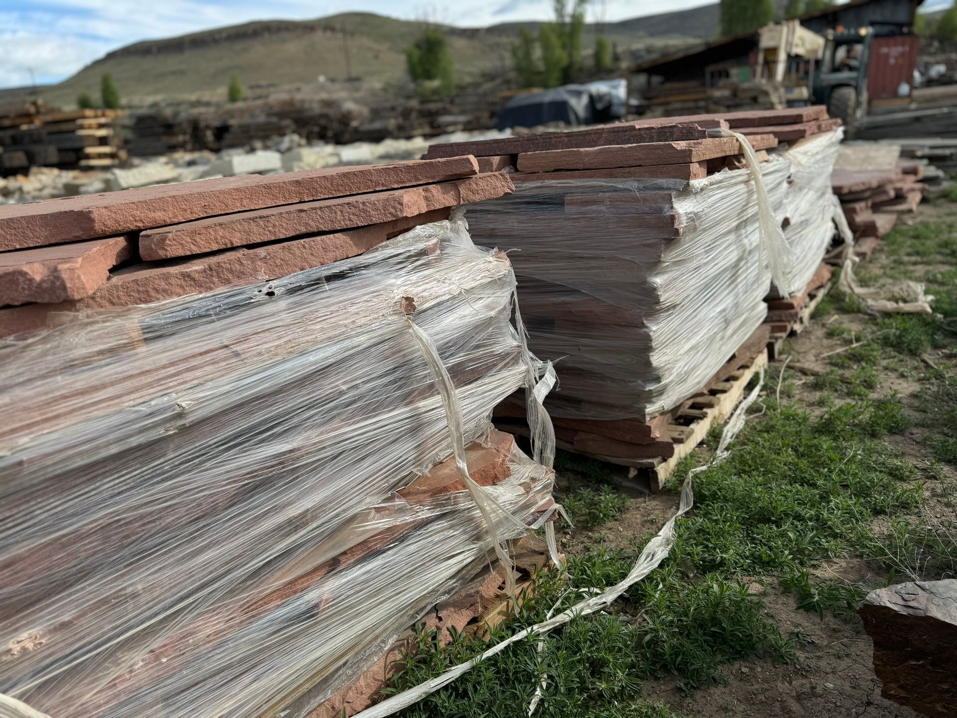 A pile of bricks wrapped in plastic is sitting on top of a wooden pallet.