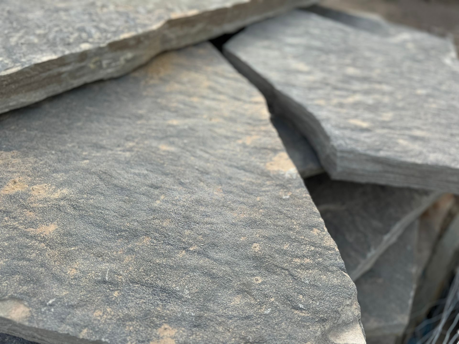 A pile of rocks is sitting on top of each other on the ground.
