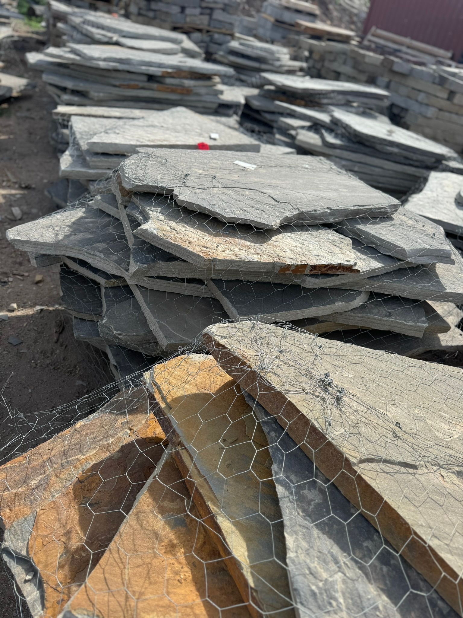 A pile of rocks is sitting on top of a chicken wire fence.