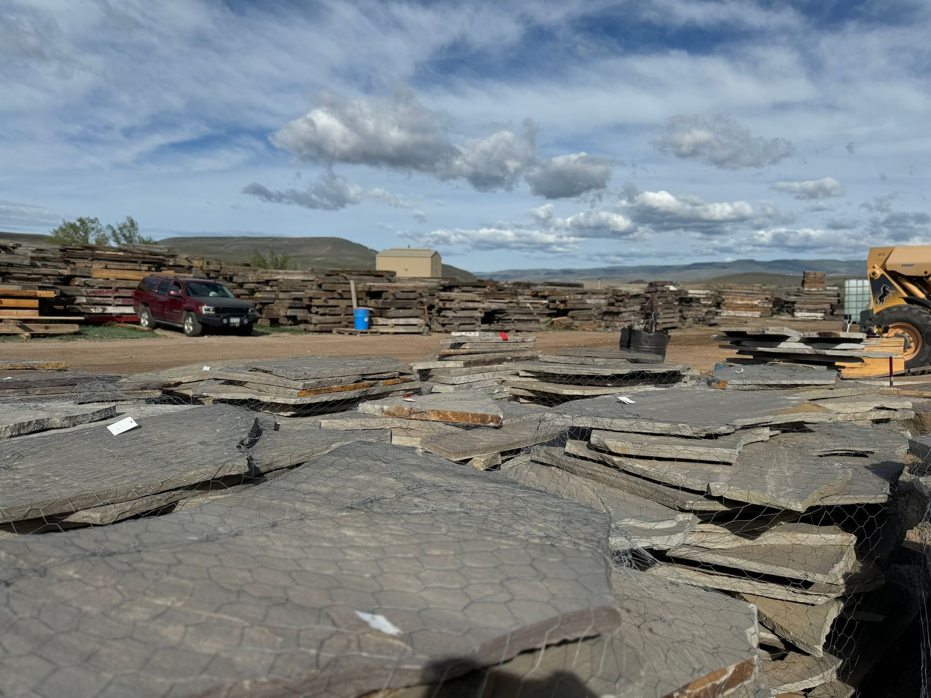 A large pile of rocks is sitting on top of a dirt field.