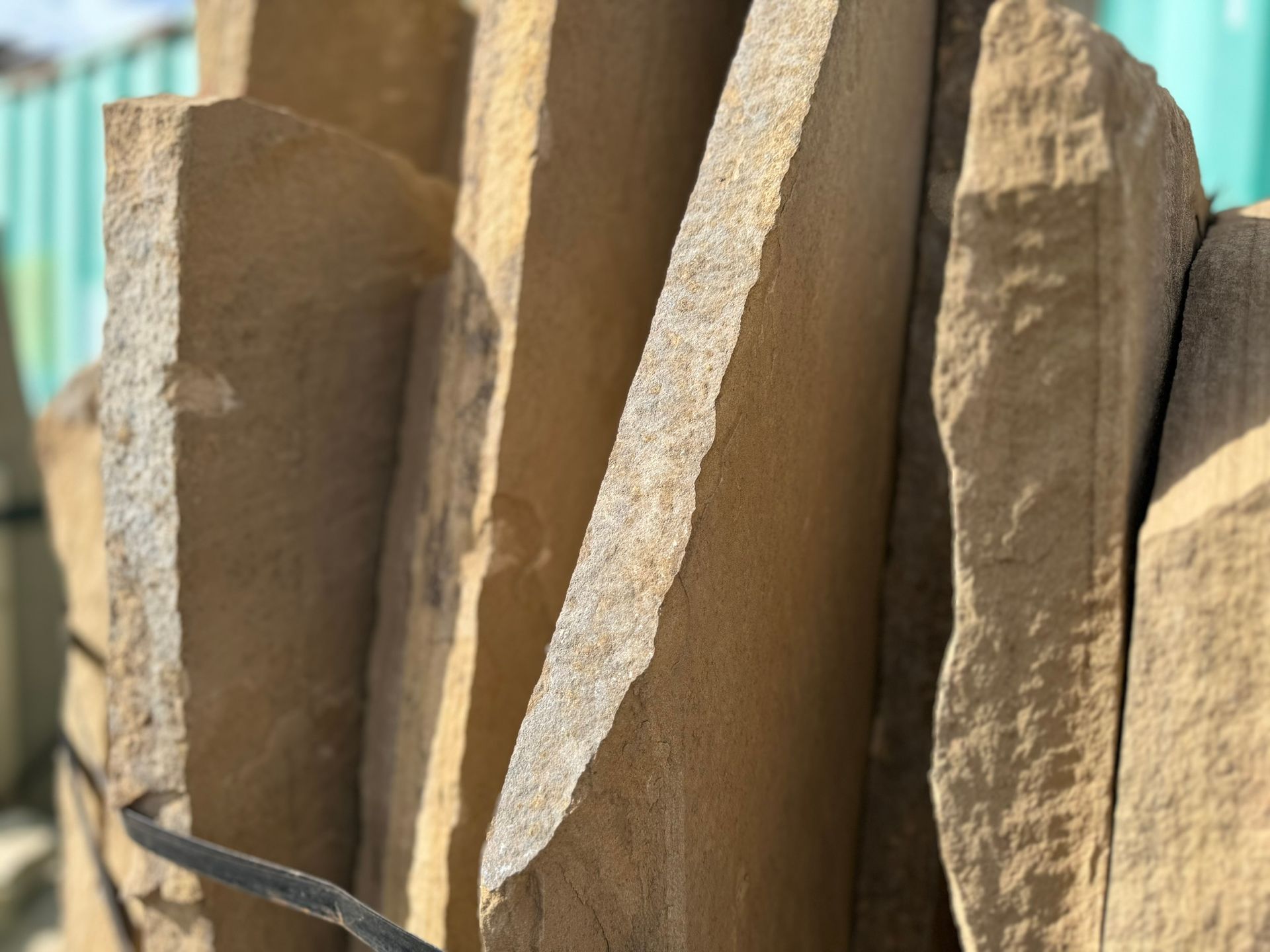 A close up of a pile of rocks with a green fence in the background.
