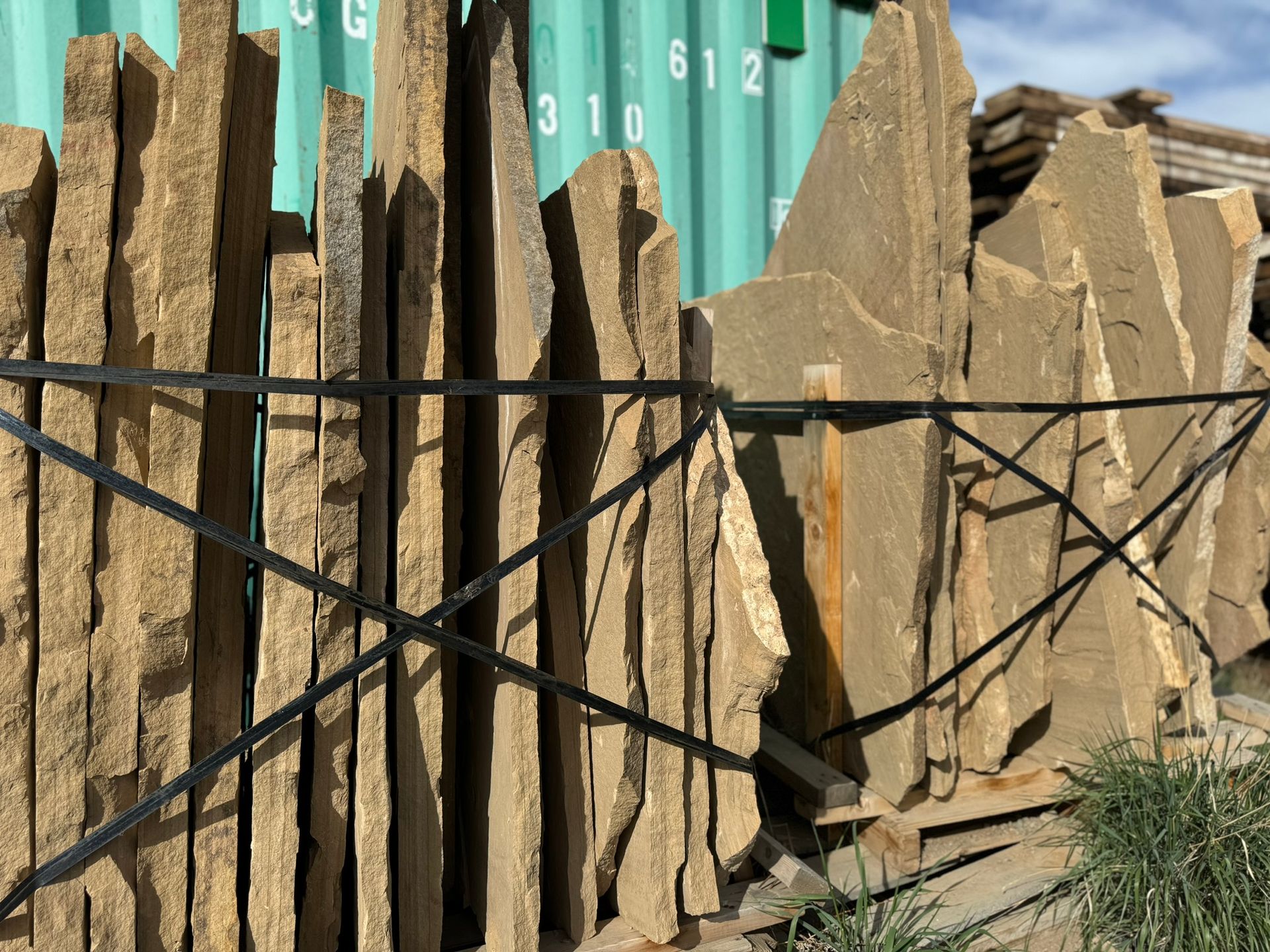 A pile of rocks sitting next to a green container with numbers on it.
