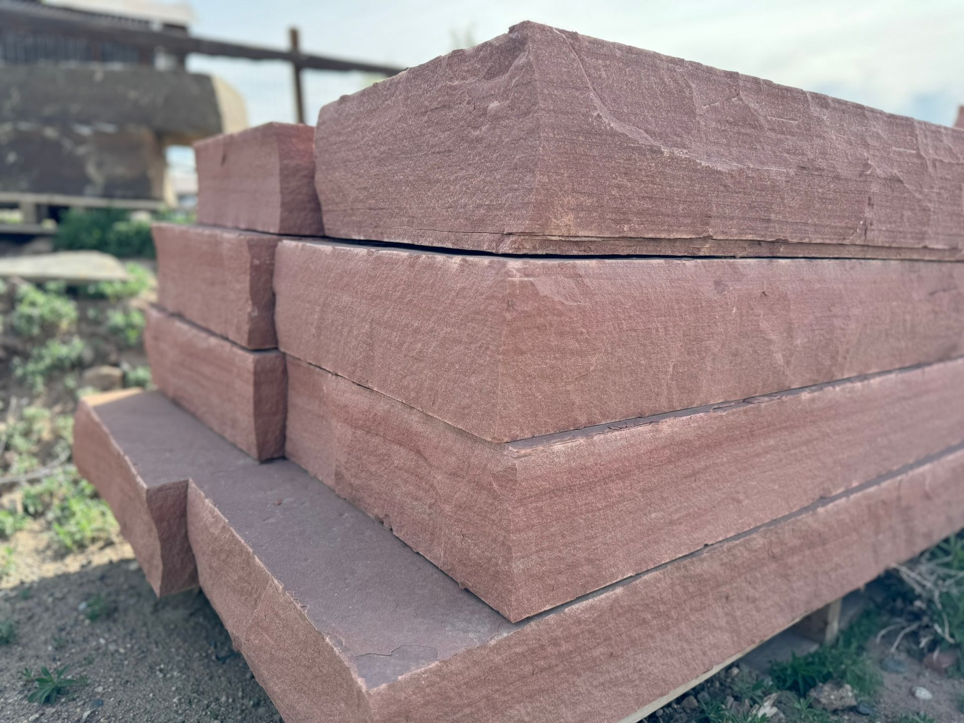 A stack of bricks sitting on top of each other on the ground.