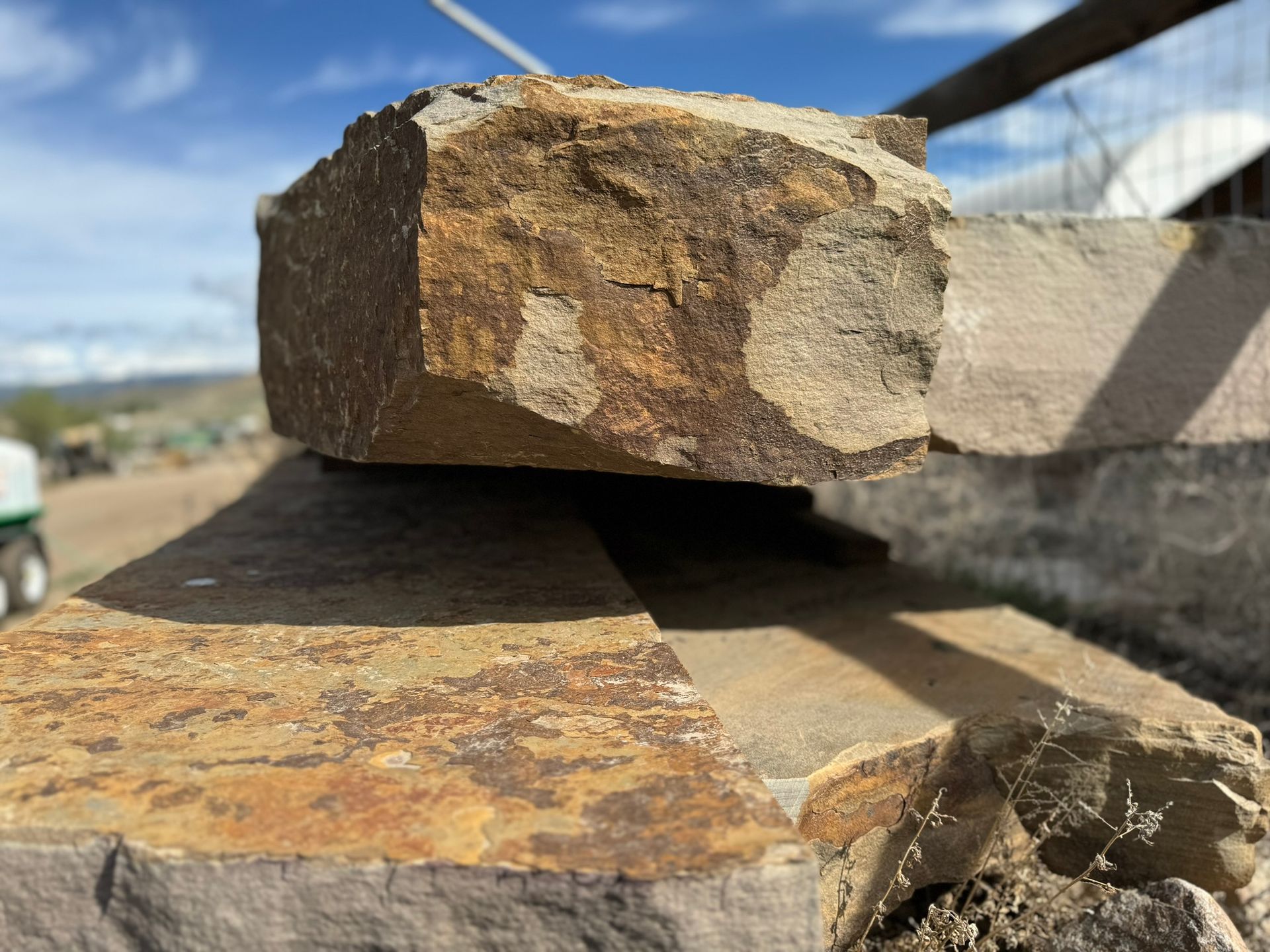 A large rock is sitting on top of a pile of bricks.