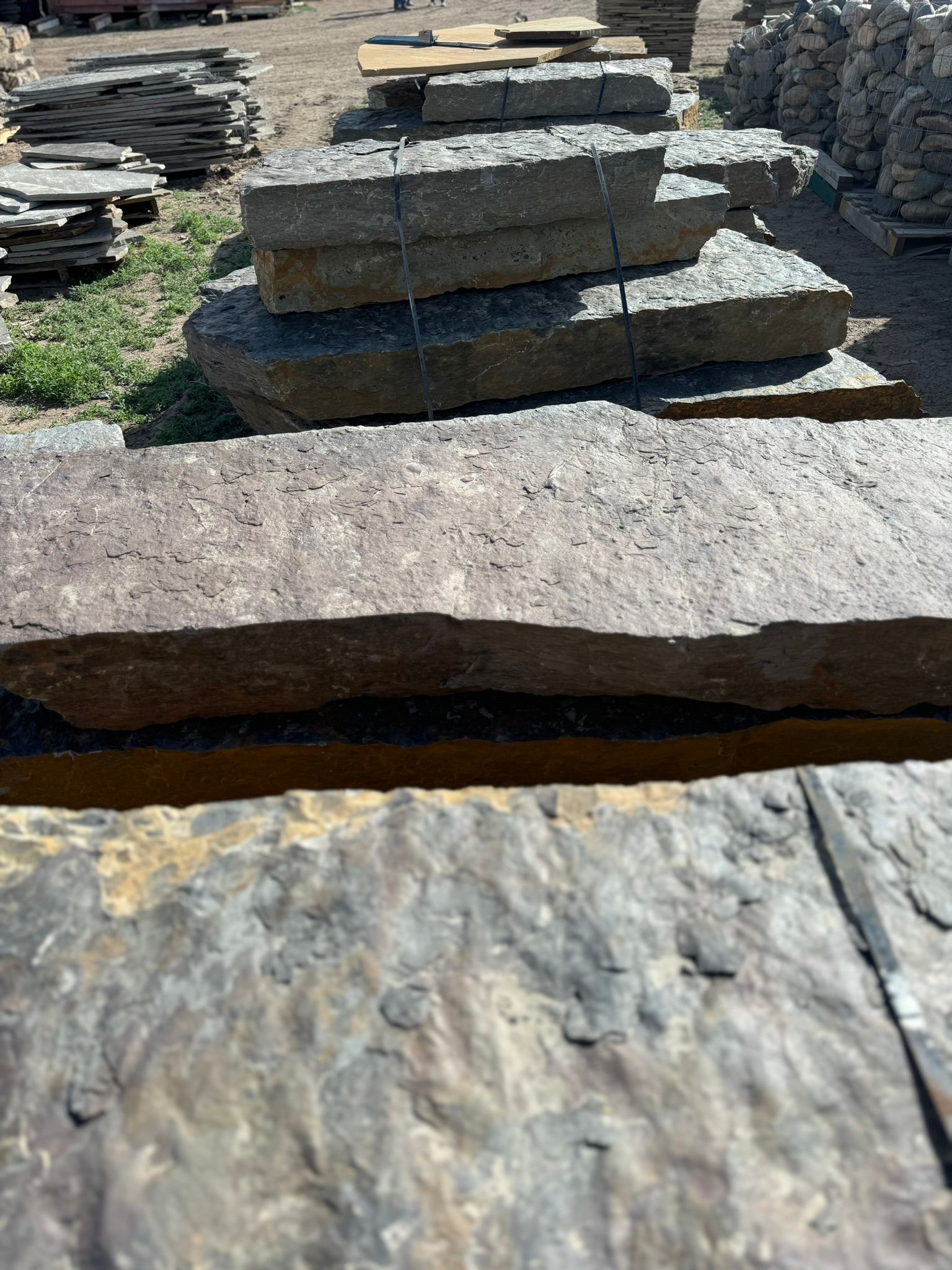A stack of bricks sitting on top of each other in a field.