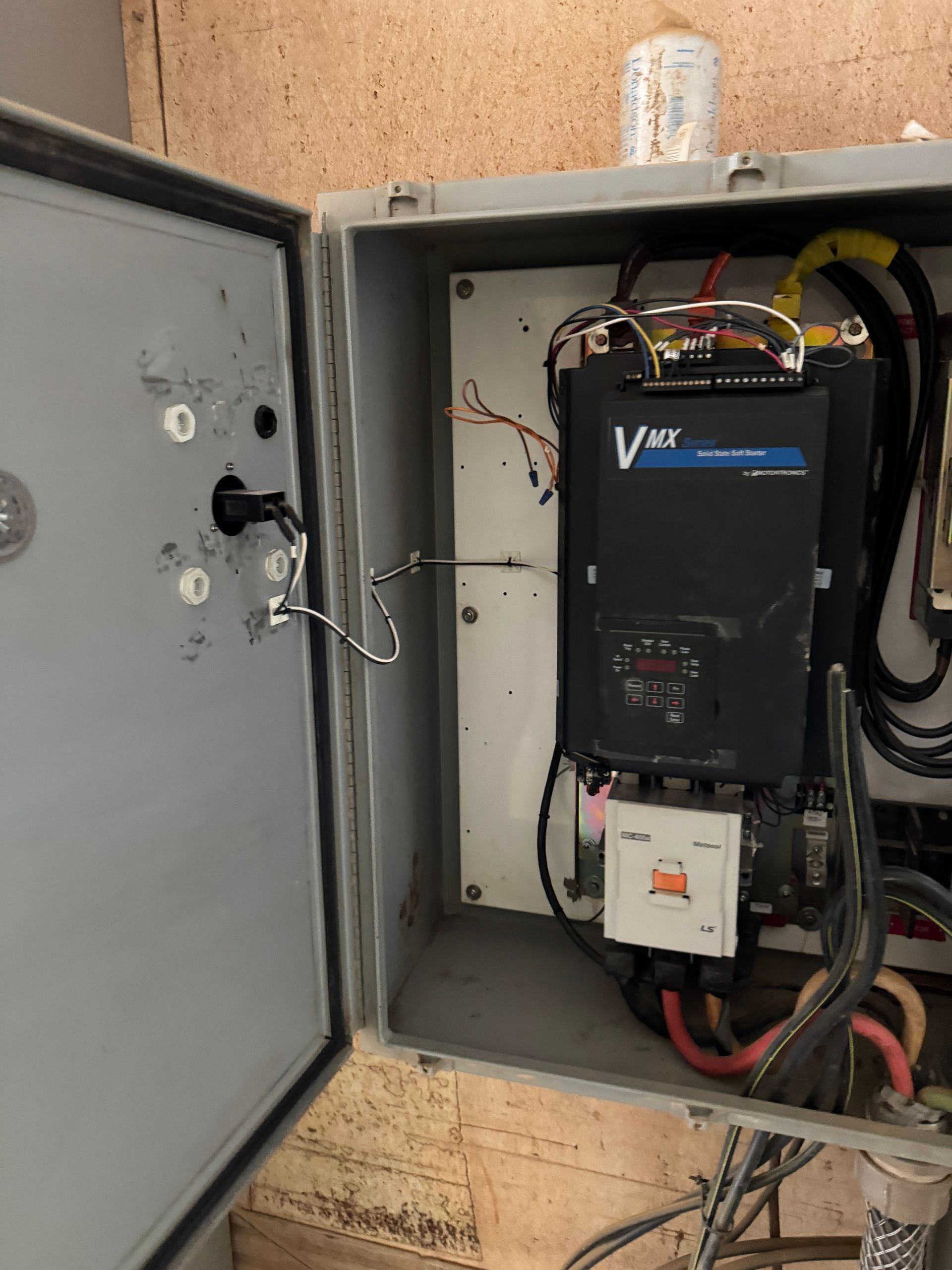 Open gray electrical box with VFD, wires, and control components.