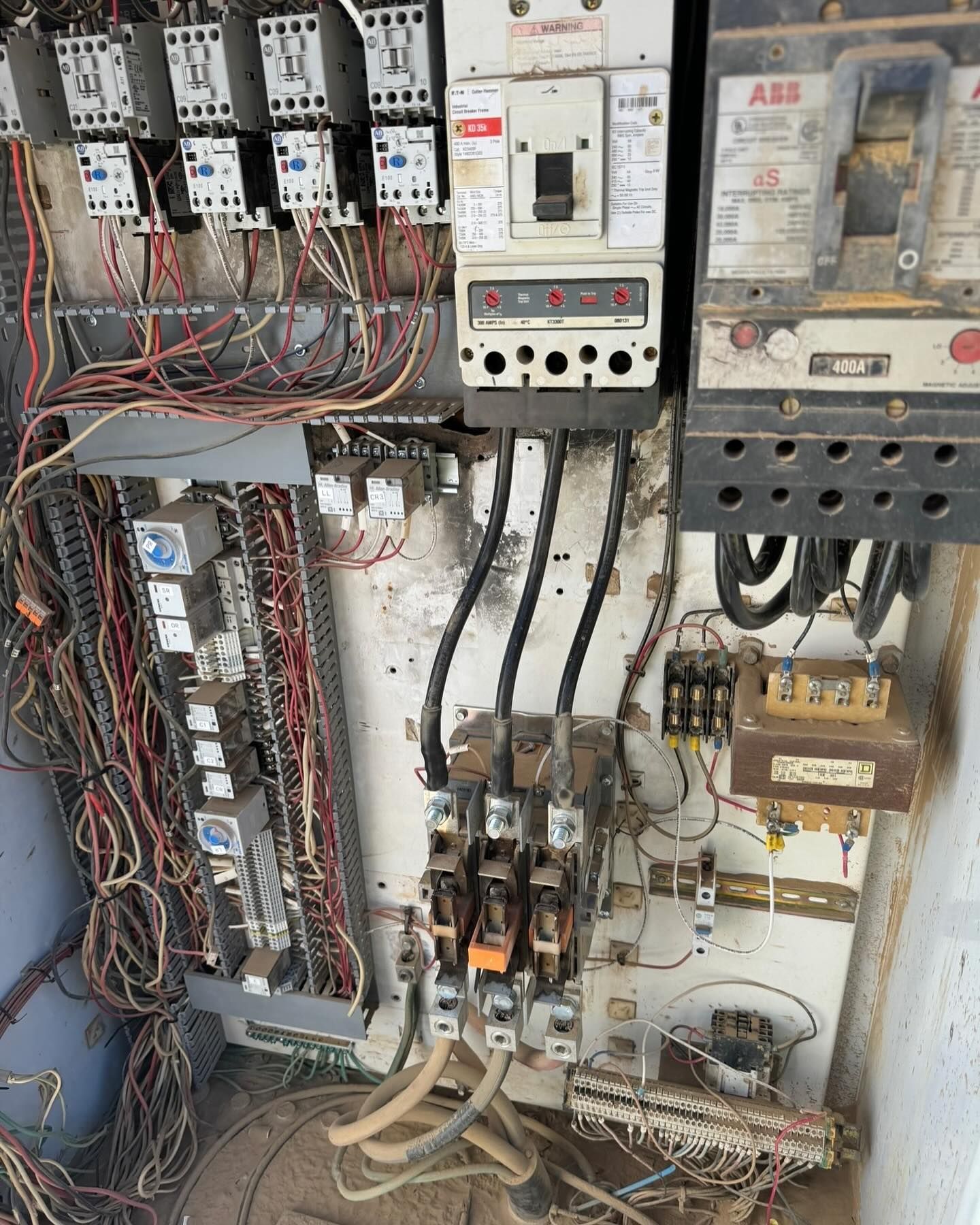 Electrical control panel with wires, breakers, and relays.