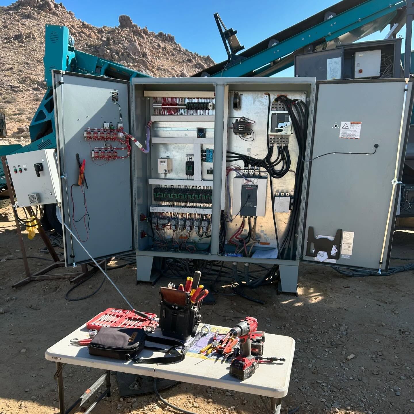 Interior wall painting with ladders, partially painted green, near stairs and window.