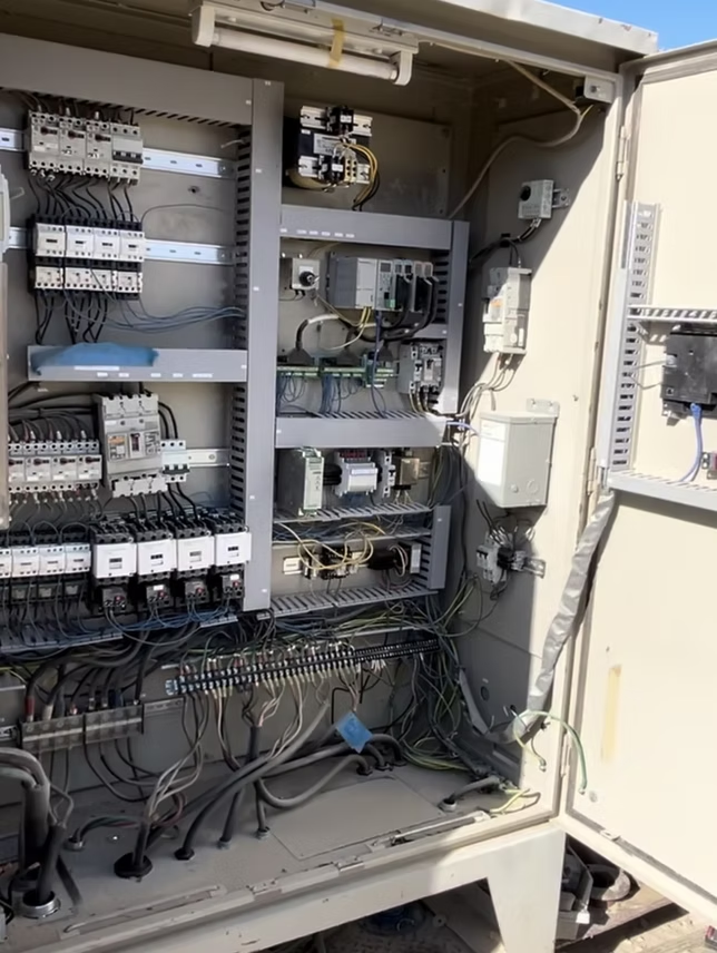 Open electrical cabinet with various components and wiring.