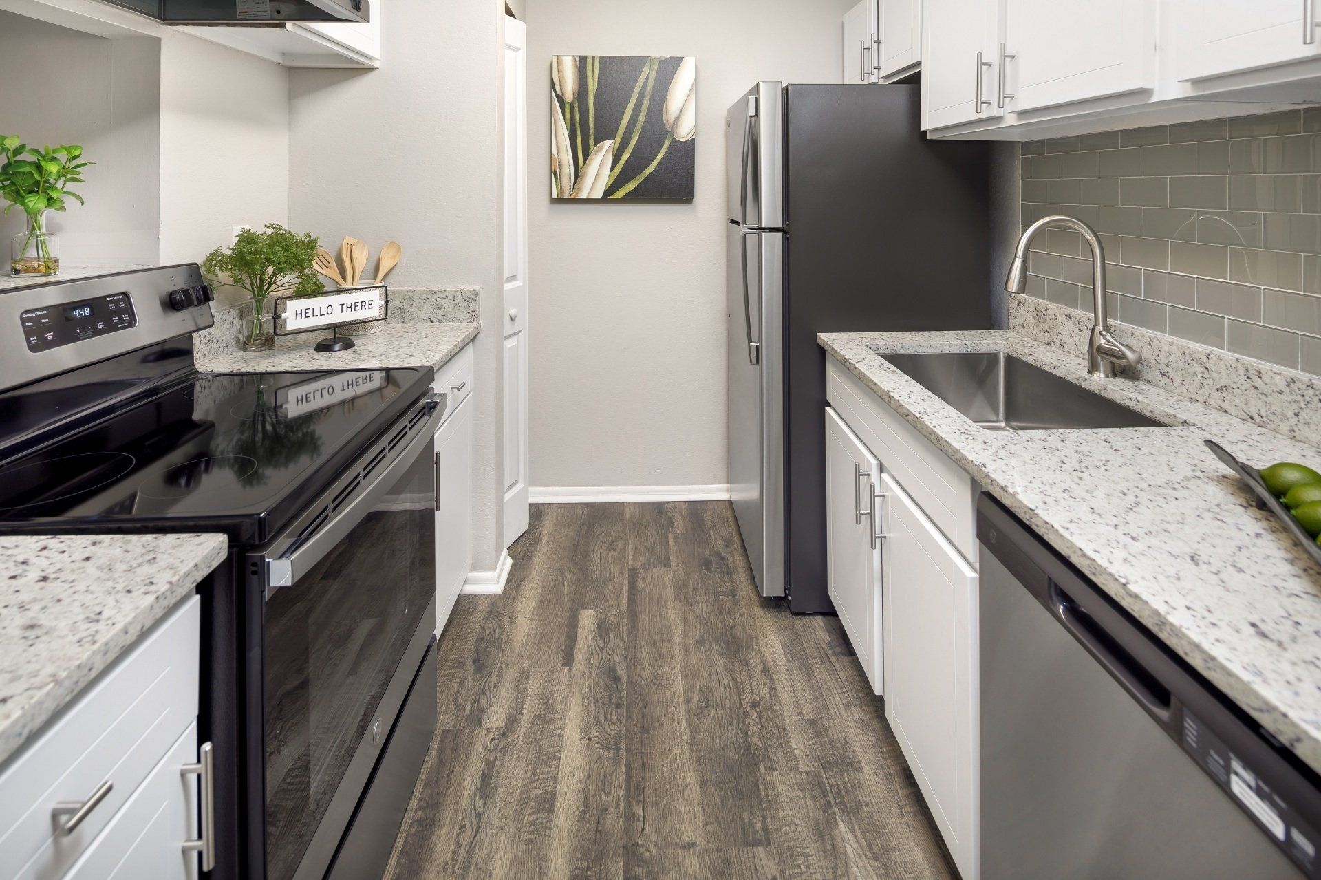 Modern kitchen with gray cabinetry, stainless steel appliances, and a gray backsplash.