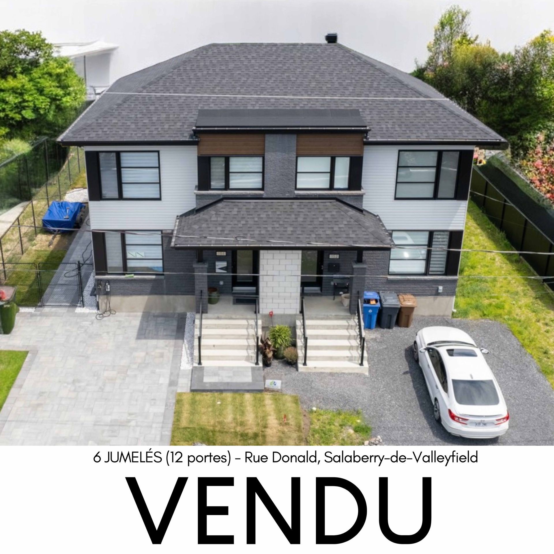 Duplex à vendre. Immeuble gris et blanc avec toit gris foncé, estampillé « VENDU » sur la façade.
