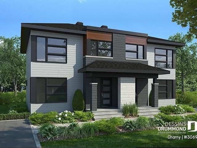 Maison moderne à deux étages avec bardage gris, boiseries noires et toit foncé. Elle dispose de grandes fenêtres et d'une cour avant paysagée.