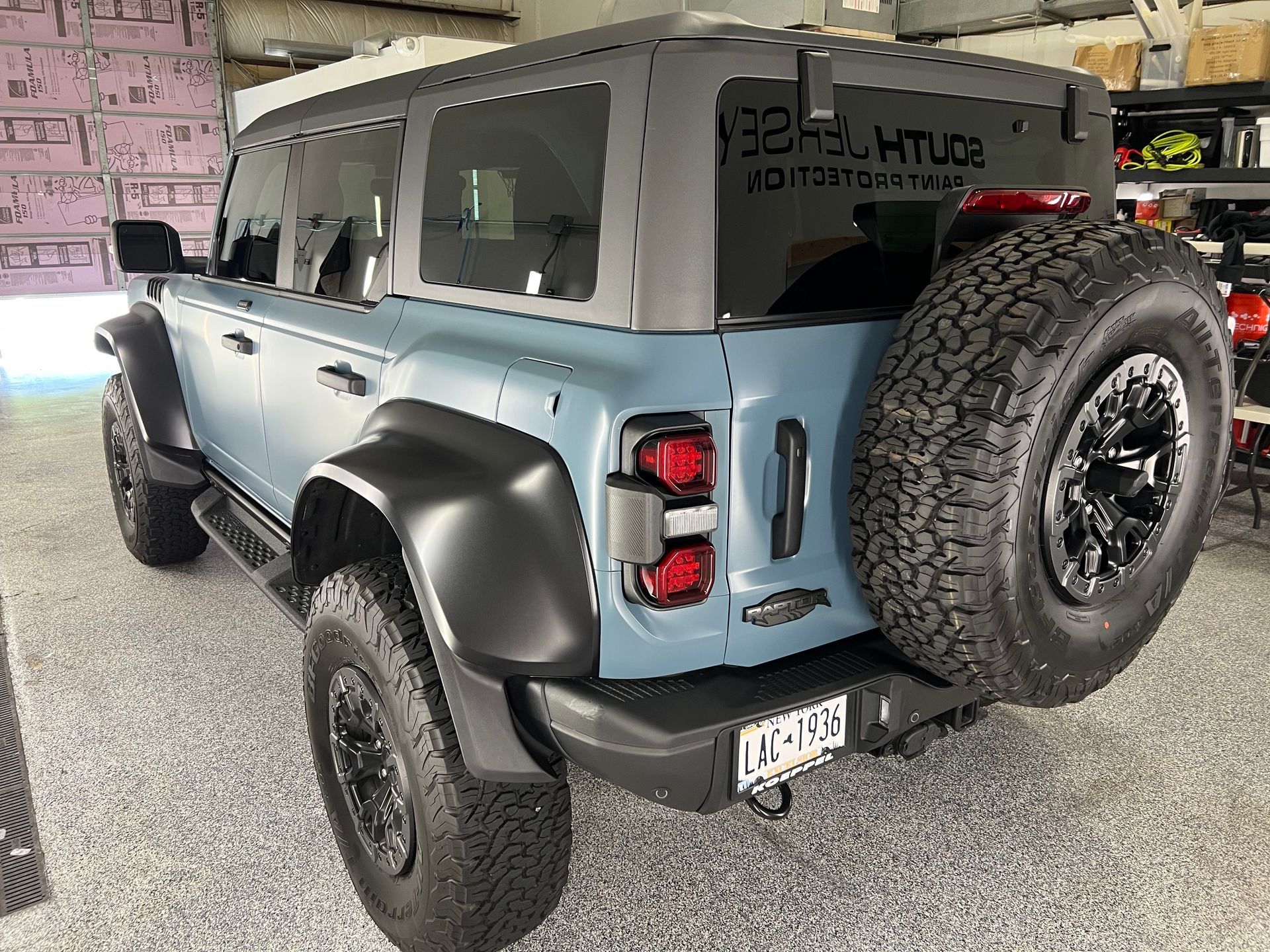 A blue jeep is parked in a garage.