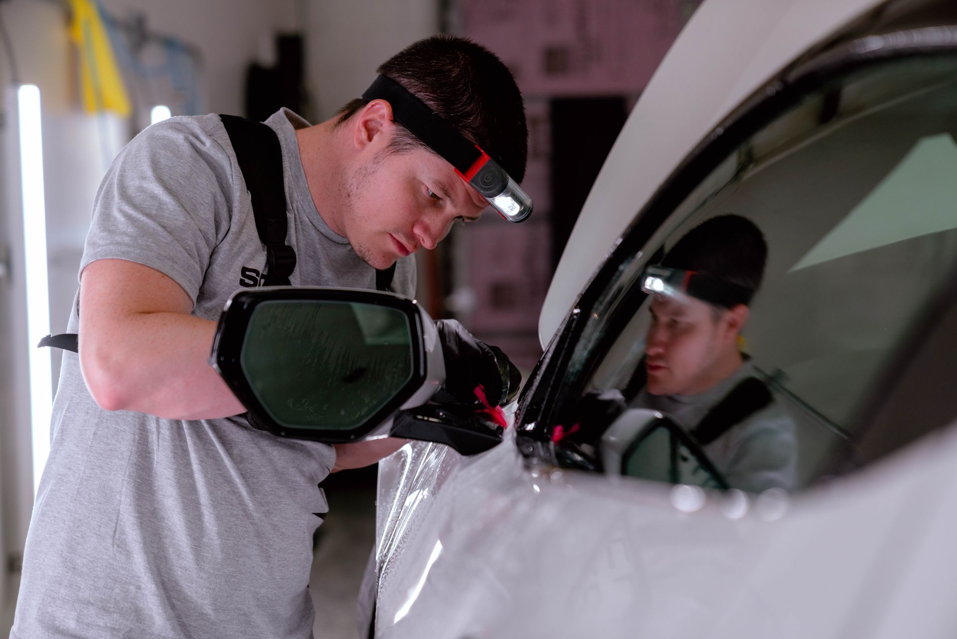 A man is working on a car in a garage.