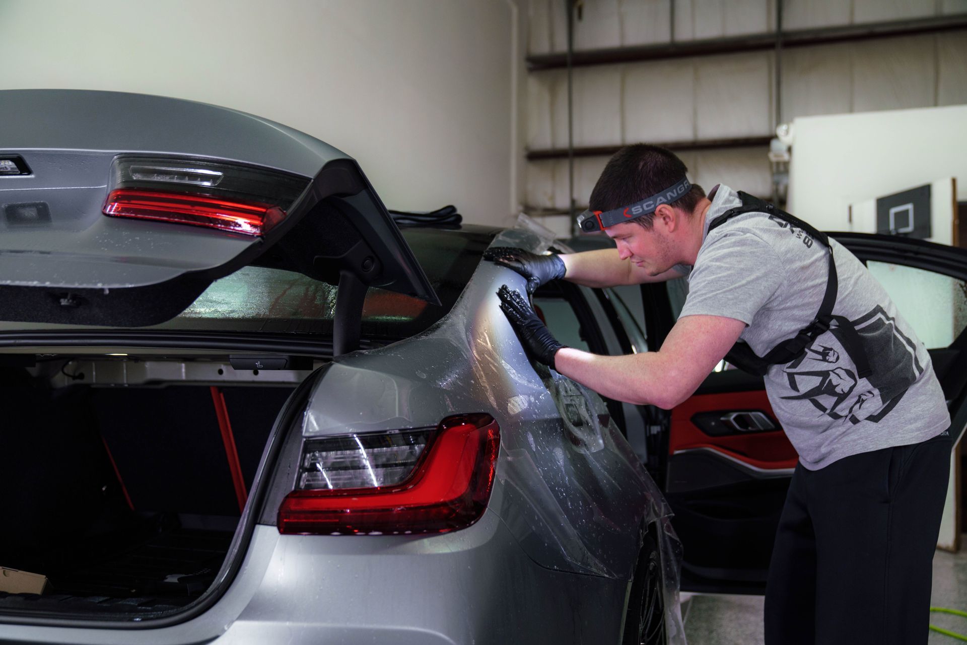 A man is working on a car in a garage.
