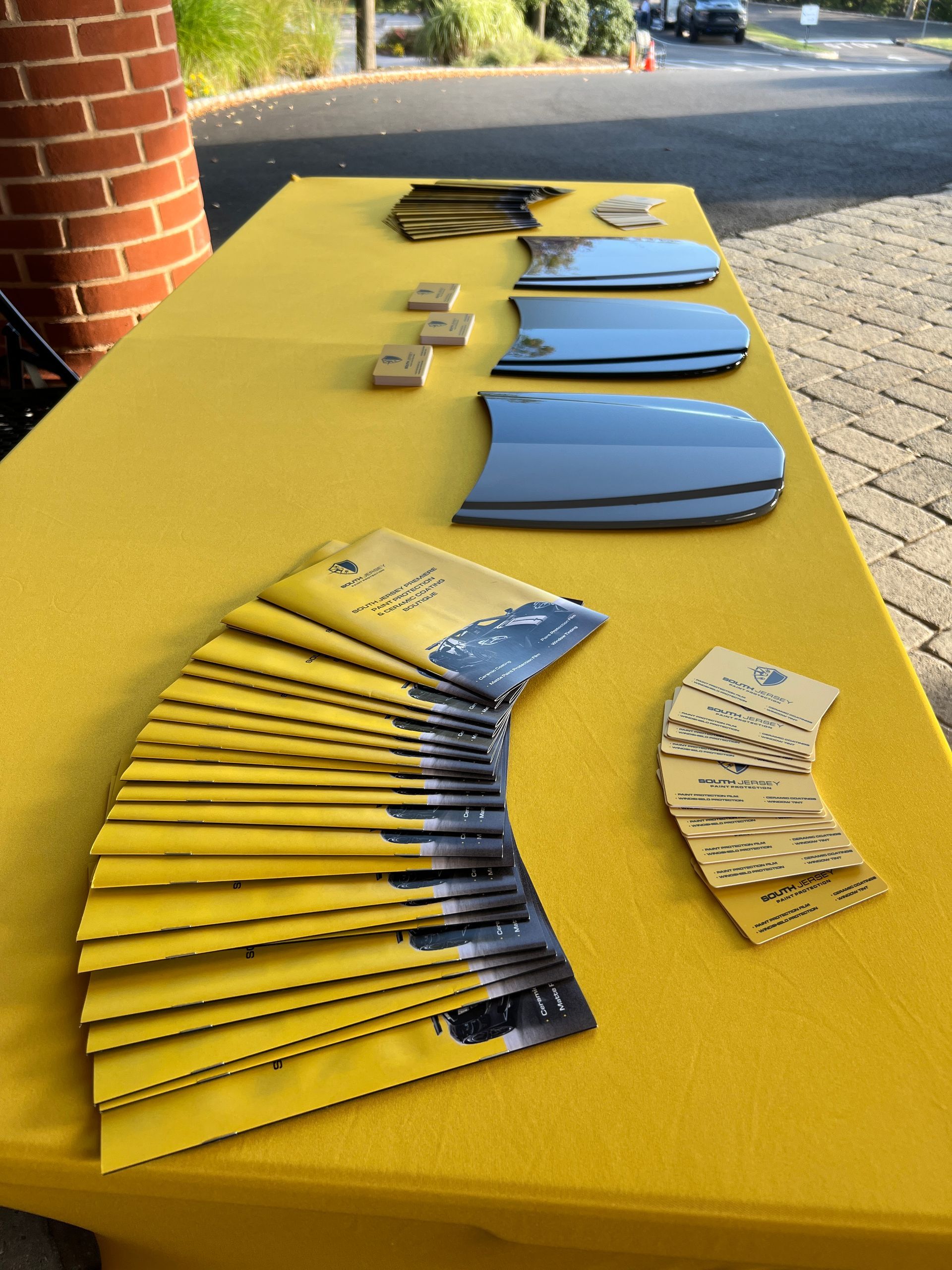 A table with a yellow table cloth and a bunch of books on it