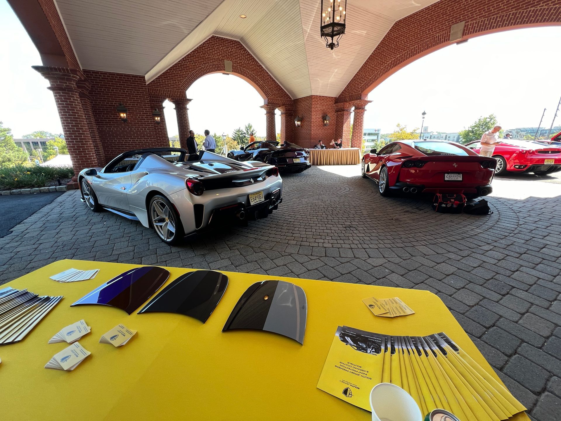 A group of cars are parked under a brick archway.