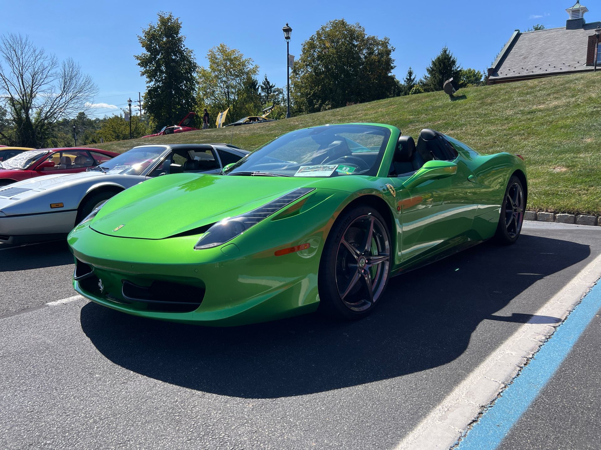 A green sports car is parked in a parking lot.