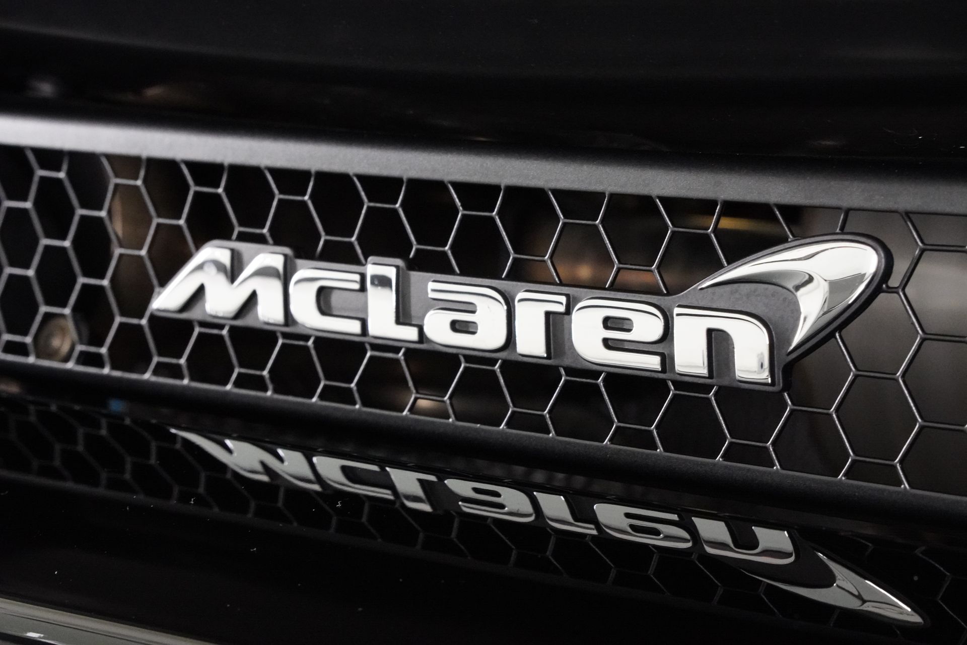 A close up of a mclaren logo on a black car