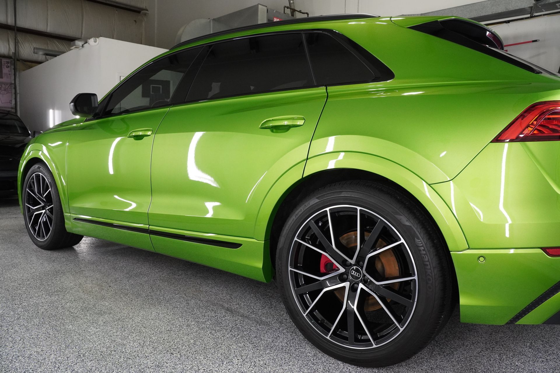 A green audi q8 is parked in a garage.