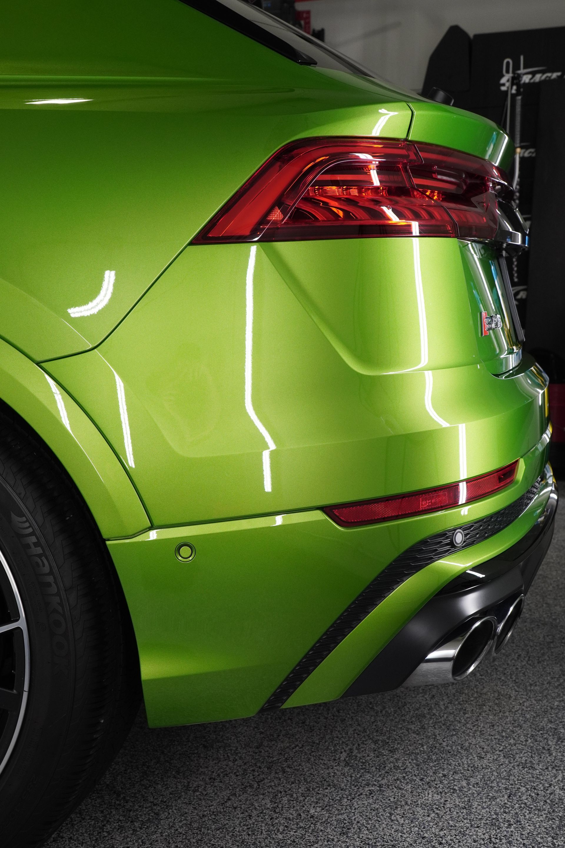A green car is parked in a garage.