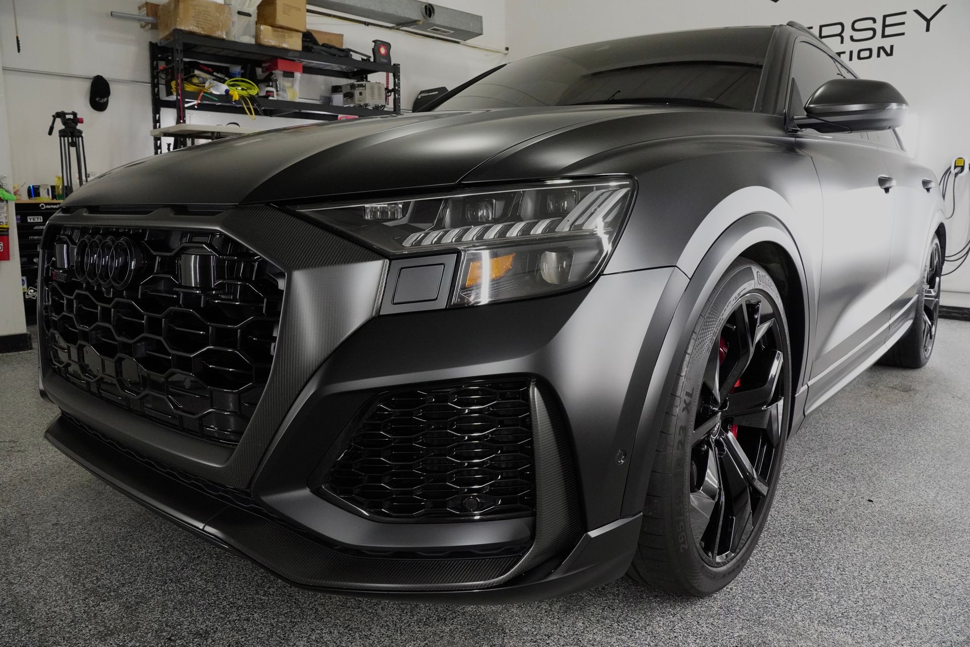A black audi q8 is parked in a garage.